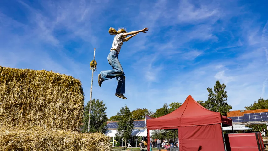 Erntedankfest Kuhhorst 2025 - Mädchen springt von Strohhüpfburg