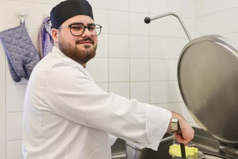 Koch-Azubi Jose beim Kochen in der Mosaik-Kantine in der Charlottenstraße