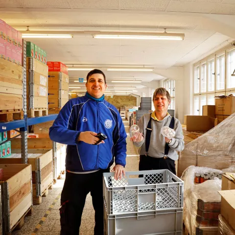 Zwei Mitarbeiter aus dem Versand in der Lagerhalle