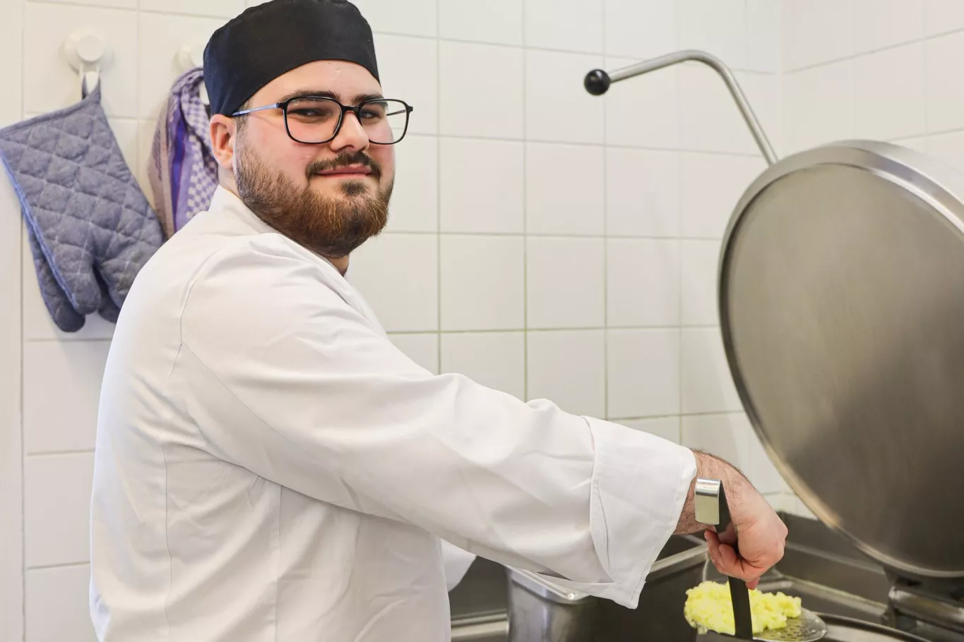 Koch-Azubi Jose beim Kochen in der Mosaik-Kantine in der Charlottenstraße