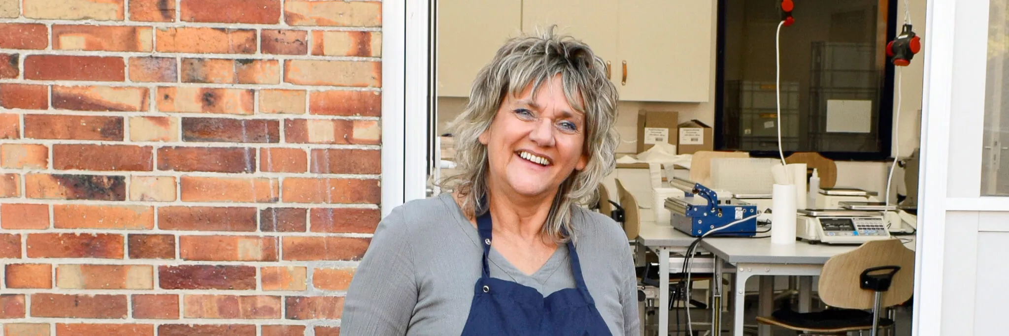 Mitarbeiterin Agnes Lichtenberg an ihrem Arbeitsplatz - Mosaik-Werkstatt für Menschen mit Behinderungen in Spandau, Bereich Lebensmittelabfüllung