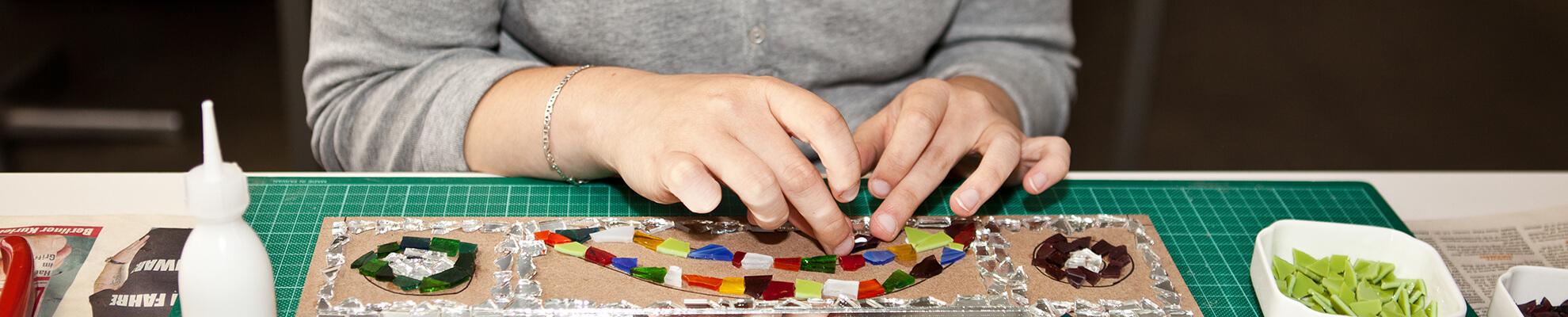 Mitarbeiterin beim Legen eines Mosaiks
