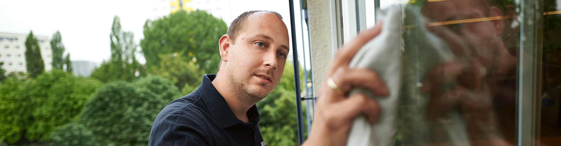 Mitarbeiter der Gebäudereinigung beim Putzen der Fenster