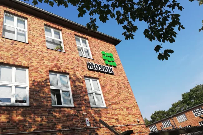 Fassade der Mosaik-Betriebsstätte Spandau mit Mosaik-Logo