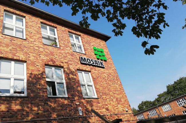Fassade der Mosaik-Betriebsstätte Spandau mit Mosaik-Logo