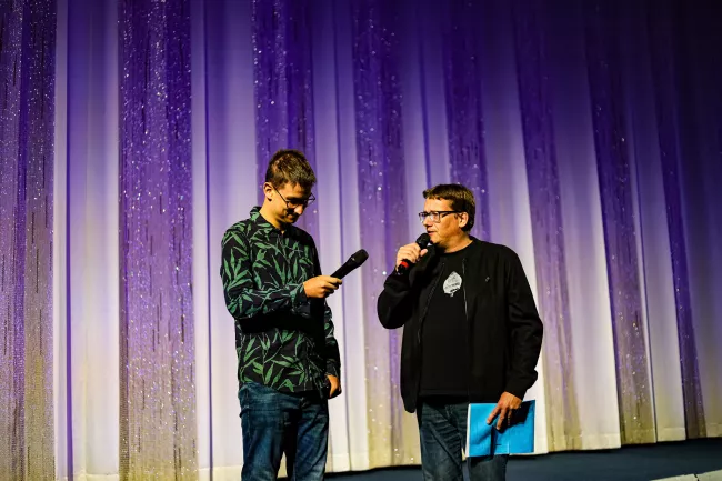 Ferdinand Kuner und Gruppenleiter Joachim Betke von Mosaik auf der Bühne des Kinos International beim Interview