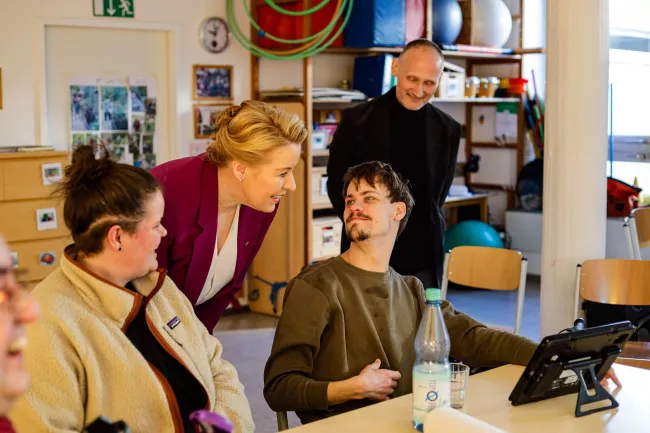 Franziska Giffey im Gespräch mit BFB-Teilnehmer Marco und seinem Talker - während ihres Besuchs bei Mosaik