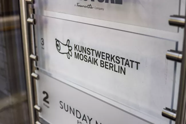 Etagenschild am neuen Standort - Logo der Kunstwerkstatt Mosaik Berlin in den Mercator-Höfen
