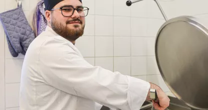 Koch-Azubi Jose beim Kochen in der Mosaik-Kantine in der Charlottenstraße