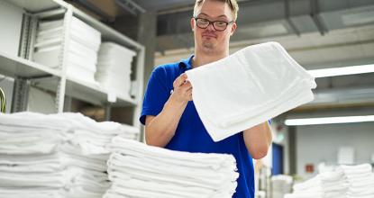Mitarbeiter der Wäscherei beim Zusammenlegen von Handtüchern