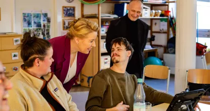 Franziska Giffey im Gespräch mit BFB-Teilnehmer Marco und seinem Talker - während ihres Besuchs bei Mosaik