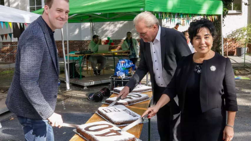 Bezirksbürgermeisterin Emine Demirbüken-Wegner schneidet gemeinsam mit Standortleiter Cornelius Haack und ehemaligem Geschäftsführer Frank Jeromin die Geburtstagskuchen an