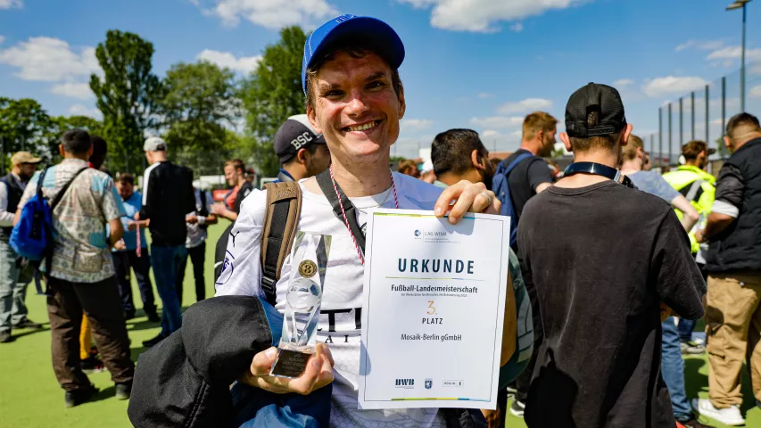 Mosaik Spieler hält Pokal und Urkunde