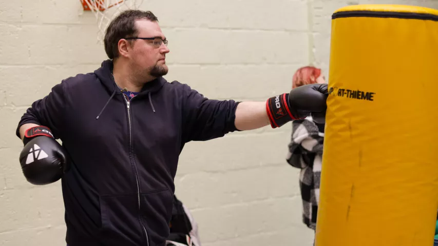 Werkstattbeschäftigter testet seine Kräfte am Sandsack - im Rahmen des Workshops Selbstbehauptung und Selbstverteidigung