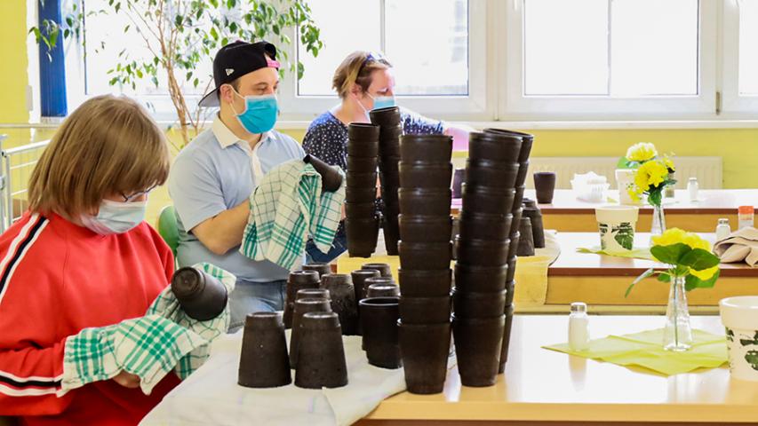 Mitarbeiter der Mosaik-Betriebsstätte Kreuzberg polieren die fertigen Kaffeeform-Becher