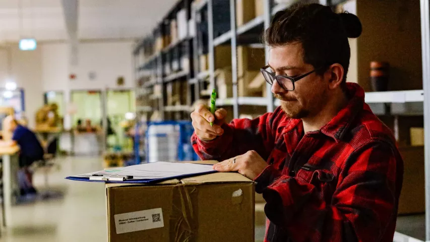 Mosaik-Mitarbeiter bei der Kontrolle des Kaffeeform-Lagerbestands