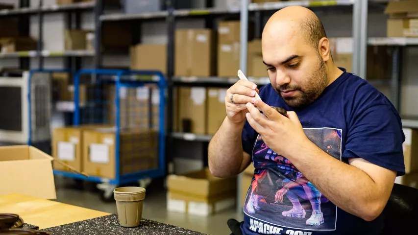 Mosaik-Mitarbeiter beim händischen Setzen der Kaffeeform-Dichtung