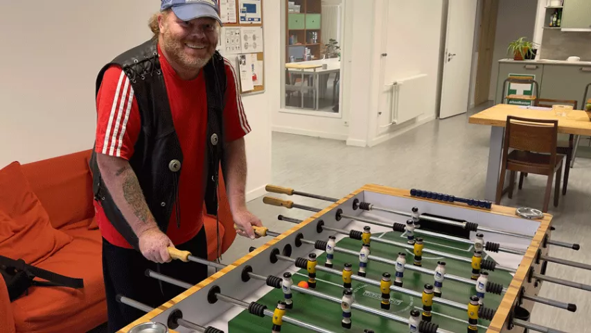 Klient beim Kickern in der Mosaik-Treffpunktwohnung in Berlin-Spandau