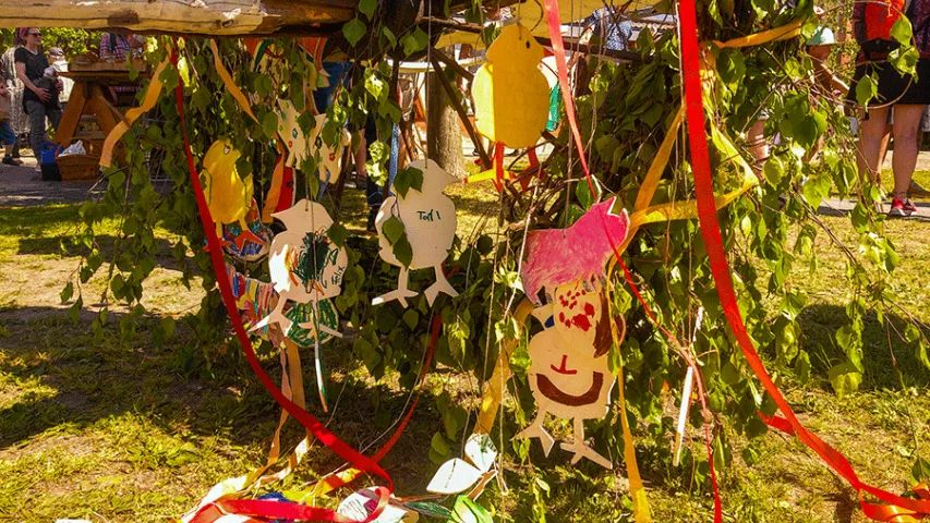 Mit bemalten Holzieren geschmückter Maibaum