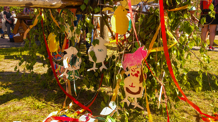 Mit bemalten Holzieren geschmückter Maibaum