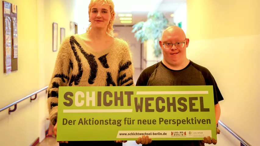 Schichtwechsel im BFB Regina-Jonas-Straße - Mitarbeiterin des Rathauses Neukölln mit BFB-Beschäftigten und Schichtwechsel-Schild