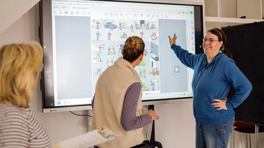 Workshop für angehenden Sicherheitsbeauftragte im Werkstattbereich - durchgeführt von der BGW - hier: Teilnehmerin erklärt etwas am Smartboard